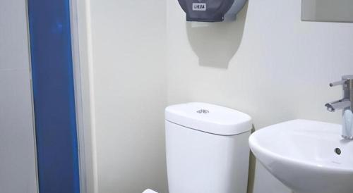 a white bathroom with a toilet and a sink at JH Hotel in Singapore