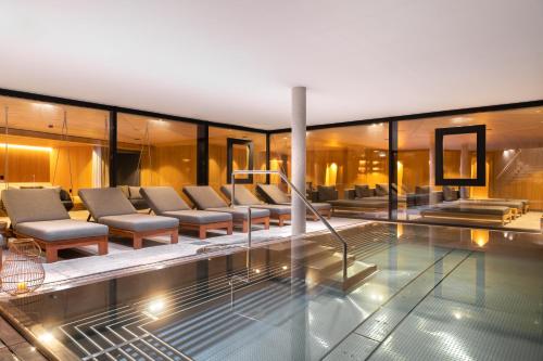 a house with a swimming pool and chairs at Gut Sonnberghof in Mittersill