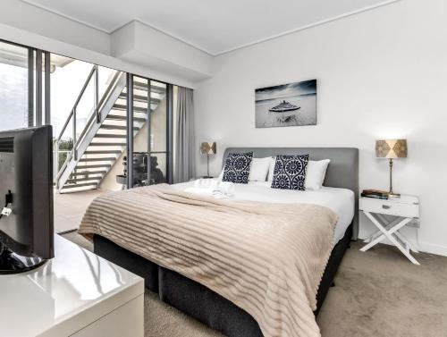 a bedroom with a large bed and a tv at Ocean View Penthouse 1328 at Bells Boulevard in Kingscliff