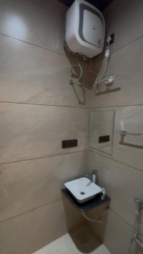 a bathroom with a toilet and a tv on the wall at BluSplash Private Pool Villa in Lakāwās