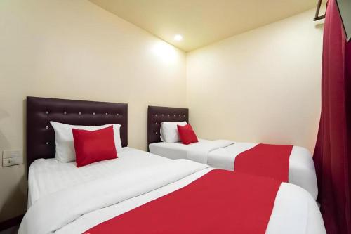 two beds in a room with red and white at 5 Diamond in Bangkok