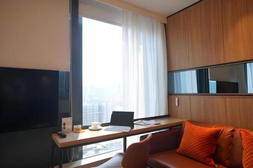 a room with a desk with a laptop and a couch at Ehotel in Hong Kong