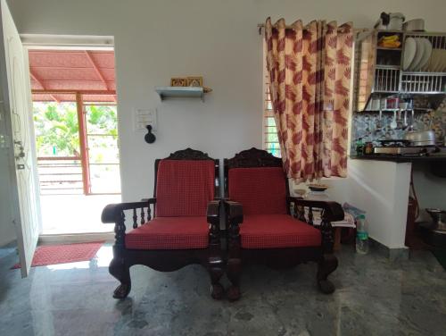 two chairs and a table in a room with a window at Mountain View Stay in Kushālnagar