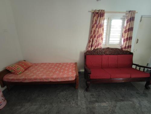 a room with two beds and a red chair at Mountain View Stay in Kushālnagar