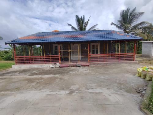a small house with a blue roof at Mountain View Stay in Kushālnagar