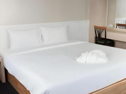 a large white bed with two pillows on it at Merlin Hotel in Sungai Kolok