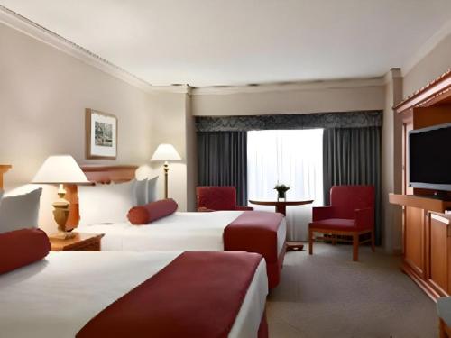 a hotel room with two beds and a flat screen tv at Harrahs Hotel Reno in Reno