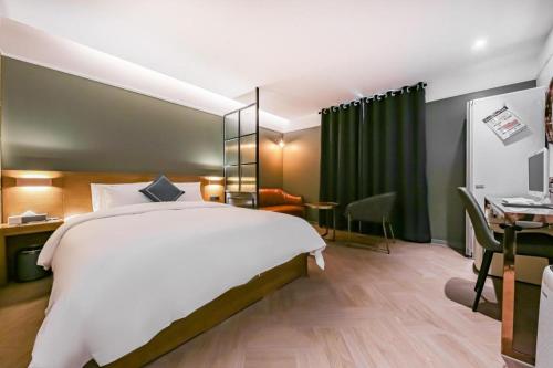 a hotel room with a large bed and a desk at Cheongju Maryjane Hotel in Cheongju