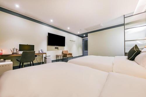 a bedroom with a bed and a desk and a television at Cheongju Maryjane Hotel in Cheongju
