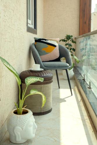 a chair sitting on a balcony with a plant at Boutique Apartments By One Tree in Jodhpur