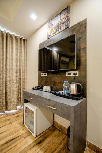 una stanza con tavolo e specchio sul muro di Lime Tree Hotel - Near Medanta Hospital a Gurgaon