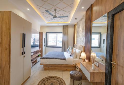 a bedroom with a bed and a bathroom with a ceiling at Boutique Apartments By One Tree in Jodhpur
