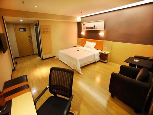 a hotel room with a bed and a chair at 7 Days Premium Nanjing Gaochun Beiling Road Branch in Gaochun