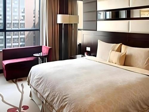 a bedroom with a large bed and a large window at Hohhot Hai Liang Plaza Hotel in Hohhot