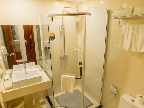 a bathroom with a shower and a sink at GreenTree Inn Taizhou New District Hospital of Renmin Hospital Mingliu Express Hotel in Jiuligou