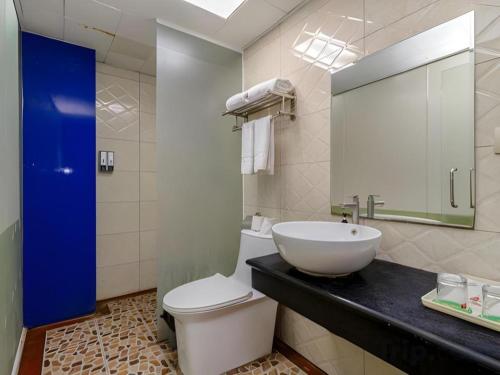 a bathroom with a sink and a toilet and a mirror at Jian Guo Grand Hotel in Vientiane