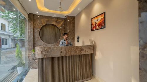 a man standing at a counter with a mirror at Aalaya Suites By Perfect Stayz in Haridwār