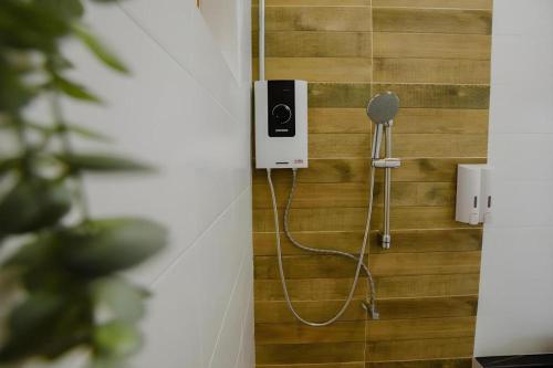 a shower with a hose attached to a wall at Nornnadubua in Uthai Thani