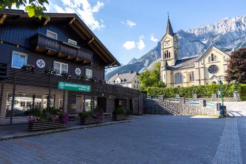 a town with a church and a building with a clock tower at Die Bergretter Appartements in Ramsau am Dachstein