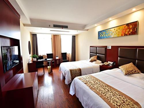 a hotel room with two beds and a desk at GreenTree Inn Anhui Xuancheng Ningguo NinGYAng East Road Darunfa Branch in Xuanzhou