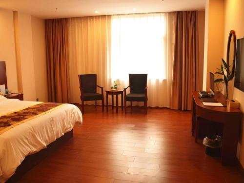 a hotel room with a bed and a table and chairs at GreenTree Inn Anhui Xuancheng Ningguo NinGYAng East Road Darunfa Branch in Xuanzhou