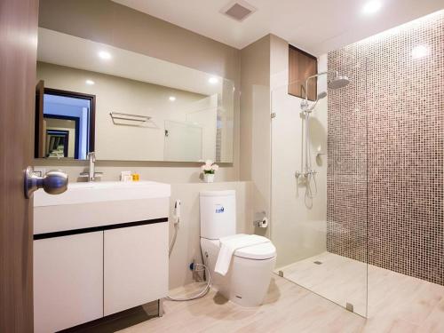 a bathroom with a toilet and a sink and a shower at Green Valley Executive Serviced Residence in Chiang Mai