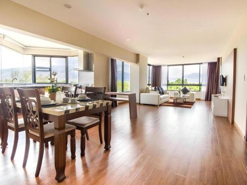 a dining room with a table and chairs and a living room at Green Valley Executive Serviced Residence in Chiang Mai