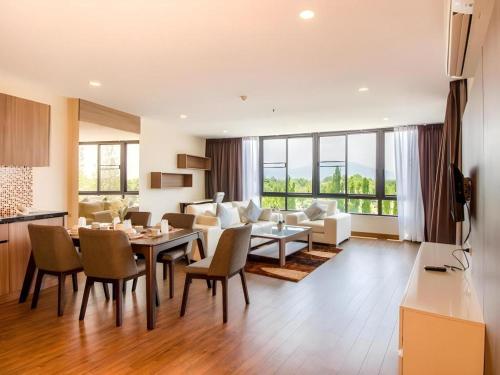 a dining room and living room with a table and chairs at Green Valley Executive Serviced Residence in Chiang Mai