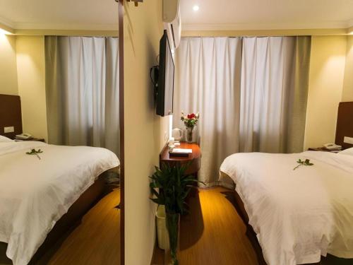 a hotel room with two beds and a mirror at GreenTree Inn Suzhou Guanqian Street Leqiao Metro Station in Suzhou
