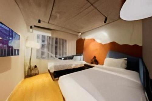 a hotel room with two beds and a lamp at YUNIK-Shanghai Zhongshan Park Yan'an Xi Road in Shanghai