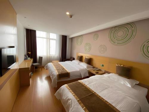 a hotel room with two beds and a television at GreenTree Inn Shanghai Fengxian District Xiaotang Metro Station in Shanghai