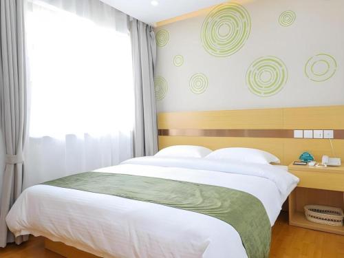 a bedroom with a large bed and a window at GreenTree Inn Jiaxin Puyuan Kaixuan Road in Jiaxing