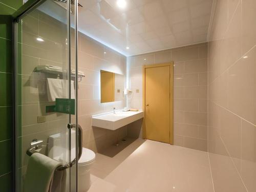 a bathroom with a toilet and a sink and a shower at GreenTree Inn Qinhuangdao Changli County Guangyuan Life Square Duanyang Street East Section in Qinhuangdao