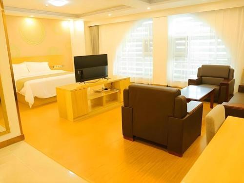 a hotel room with a bed and a television at GreenTree Inn Qinhuangdao Changli County Guangyuan Life Square Duanyang Street East Section in Qinhuangdao
