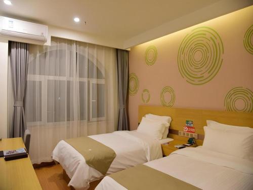 a hotel room with two beds and a window at GreenTree Inn Qinhuangdao Changli County Guangyuan Life Square Duanyang Street East Section in Qinhuangdao