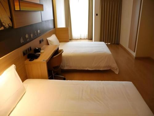 a hotel room with two beds and a desk at IU Hotel Chengdu High-Tech Zone Longhu Times Street in Chengdu