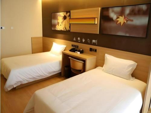 a hotel room with two beds and a desk at IU Hotel Chengdu High-Tech Zone Longhu Times Street in Chengdu