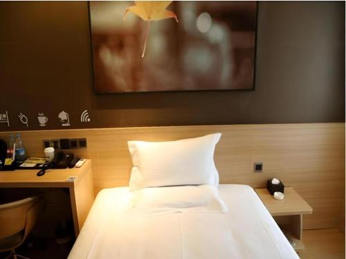 a bedroom with a bed and a desk and a picture at IU Hotel Chengdu High-Tech Zone Longhu Times Street in Chengdu