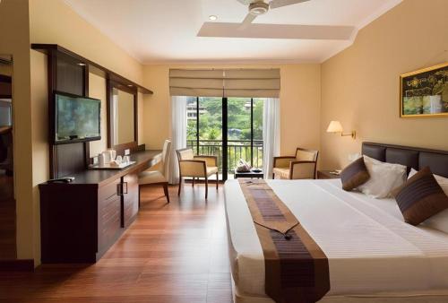 a hotel room with a large bed and a television at Devon Hotel in Kandy