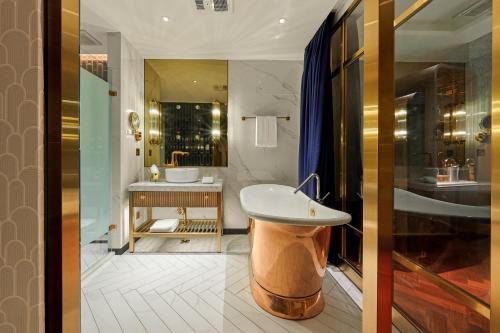 a bathroom with a sink and a tub at OKU Hotel in Taichung