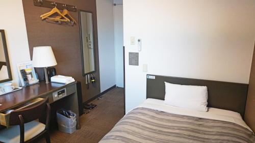 a hotel room with a bed and a desk and a desk at Hotel Route-Inn Court Ina in Ina