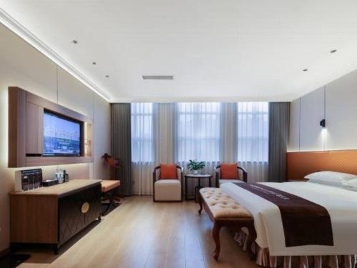 a hotel room with a large bed and a desk at Chengdu Haotian Guotai Hotel in Chengdu