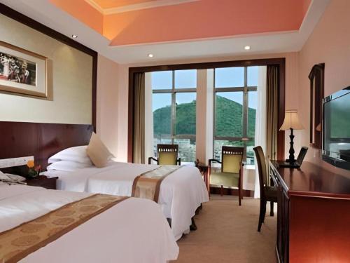 une chambre d'hôtel avec deux lits et une grande fenêtre dans l'établissement Vienna Hotel Chengdu Exhibition Center, à Chengdu