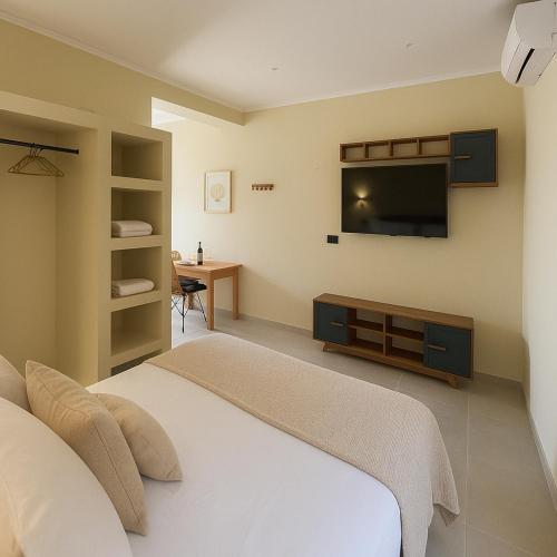 a bedroom with a bed and a flat screen tv at Mediteranno Suites in Sami