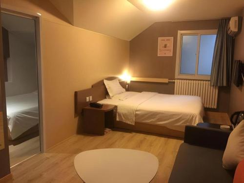 a small room with a bed and a couch at 7 Days Inn Qingdao Liaoyang West Road Xinye Plaza Metro Station in Qingdao