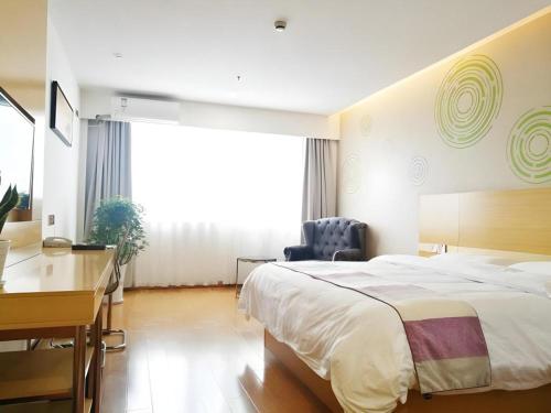 a bedroom with a bed and a desk and a chair at GreenTree Inn Yancheng Yandu District Hongxing Macalline Century Avenue in Yancheng