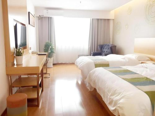 a hotel room with three beds and a desk at GreenTree Inn Yancheng Yandu District Hongxing Macalline Century Avenue in Yancheng