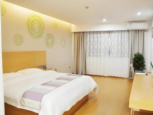a bedroom with a large bed and a window at GreenTree Inn Yancheng Yandu District Hongxing Macalline Century Avenue in Yancheng