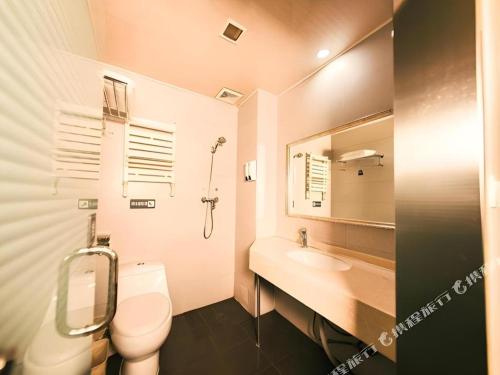 a bathroom with a toilet and a sink and a mirror at 7 Days Inn Harbin Medical University First Affiliated Hospital in Harbin