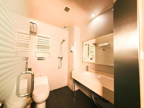 a bathroom with a toilet and a sink and a mirror at 7 Days Inn Harbin Medical University First Affiliated Hospital in Harbin